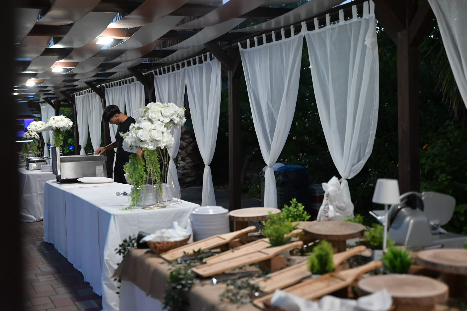 Il buffet della sera in preparazione sotto il pergolato illuminato